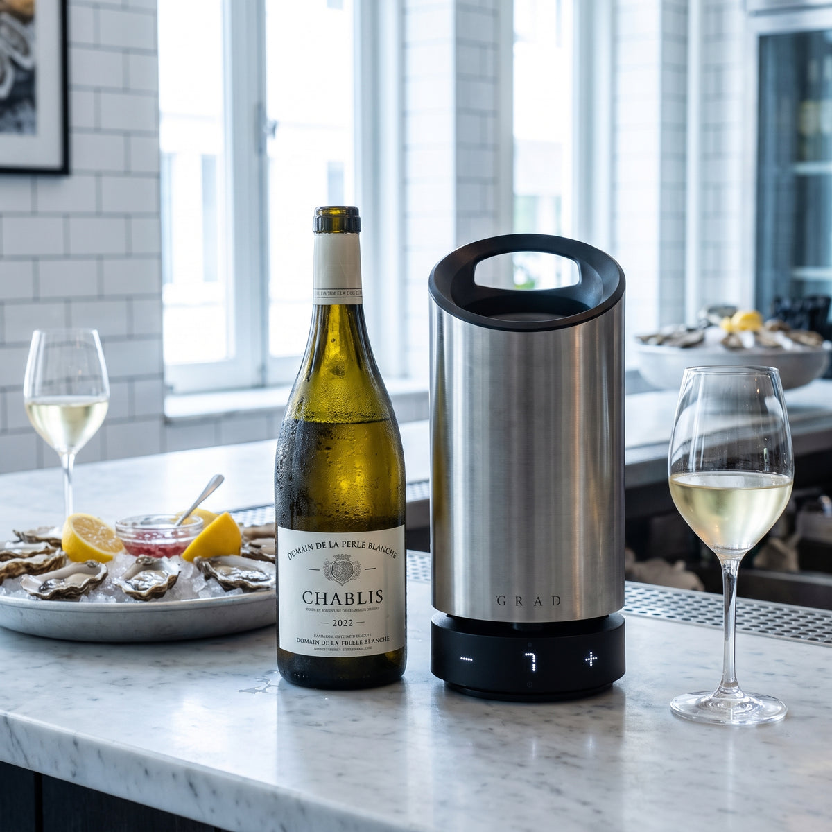 GRAD No.1 Steel Series vinkylare bredvid en flaska Chablis och färska ostron på en bardisk i marmor